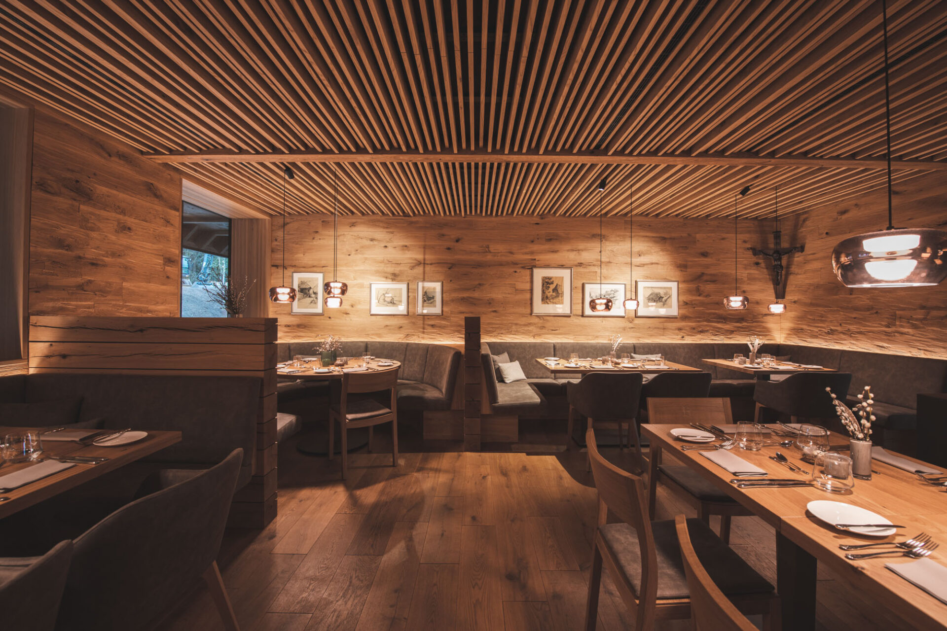 Gemütliches Restaurant mit Holzdekor, stilvoller Beleuchtung und gedeckten Tischen.