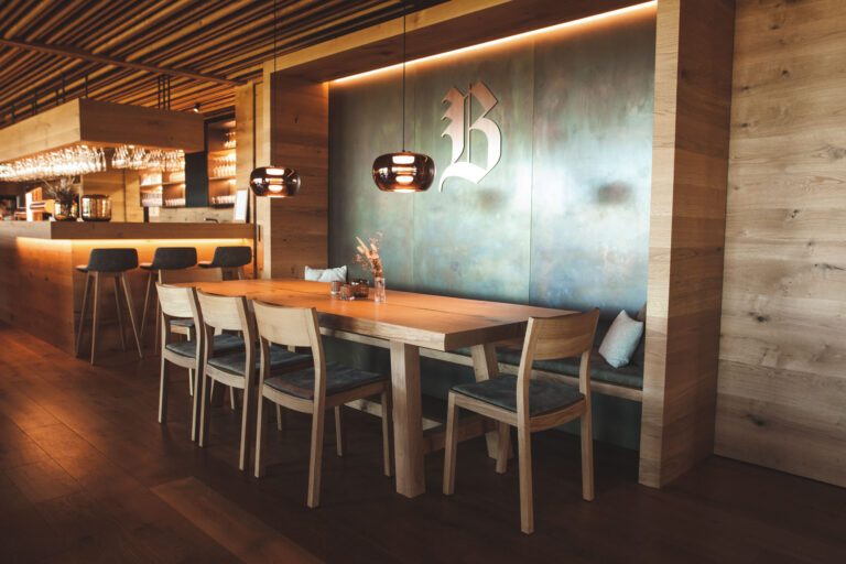 Modernes Restaurant mit Holzdekor, Sitzgelegenheiten und stilvoller Beleuchtung.