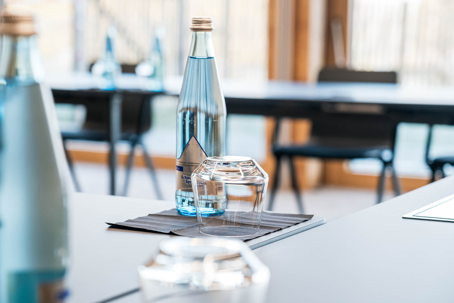 Wasserflasche und Glas auf einem Tisch im modernen Restaurant.