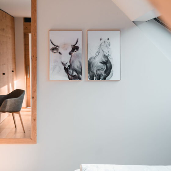 Moderner Schlafzimmerbereich mit Tierporträts an weißer Wand und Holzdekor.