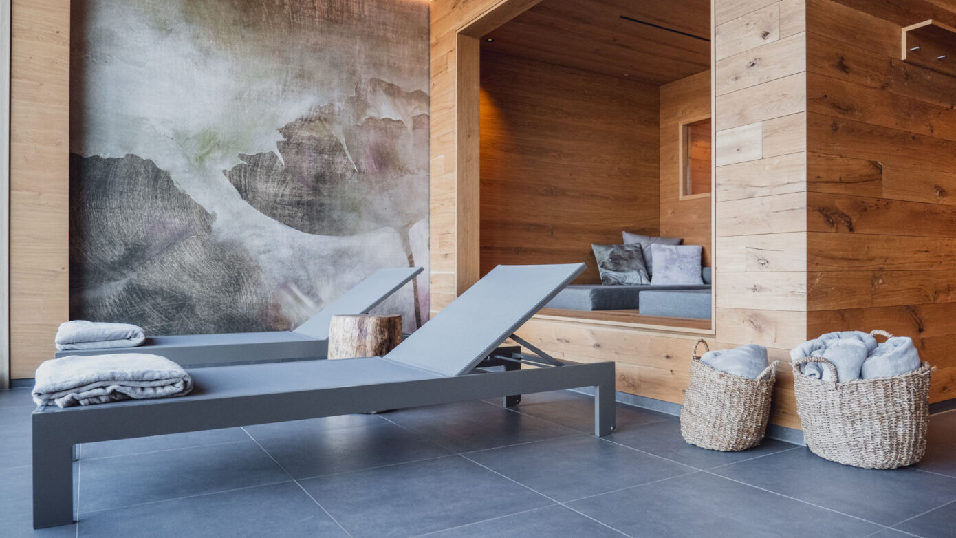 Entspannungsbereich mit Liegestühlen, Holzdekor, Wandkunst und Handtüchern im Spa.