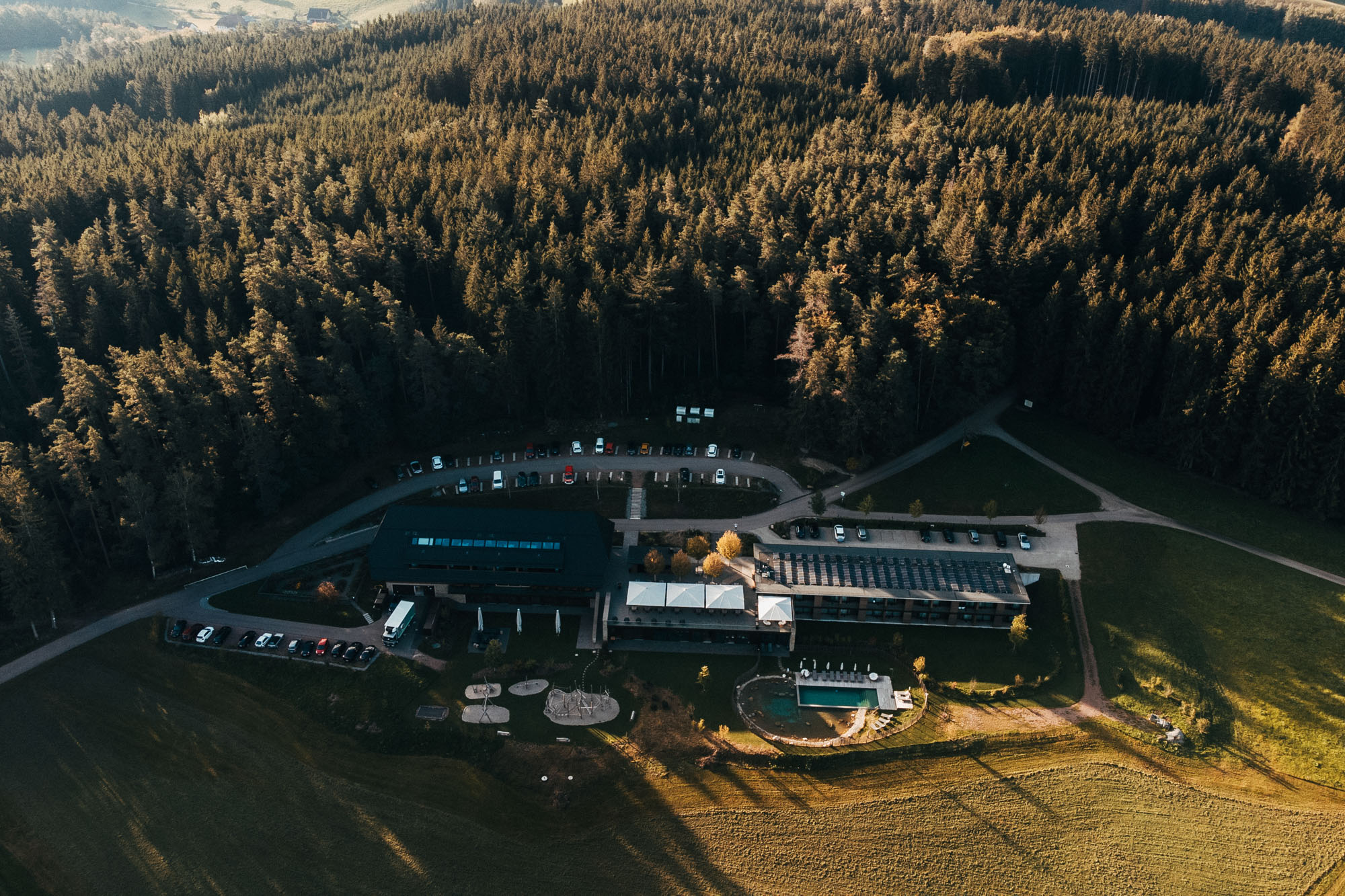 Modernes Hotel in Waldnähe mit Pool, Parkplätzen und Sonnenterrasse.