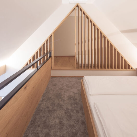 Modernes Schlafzimmer mit Holzdetails und Dachgeschoss-Design.