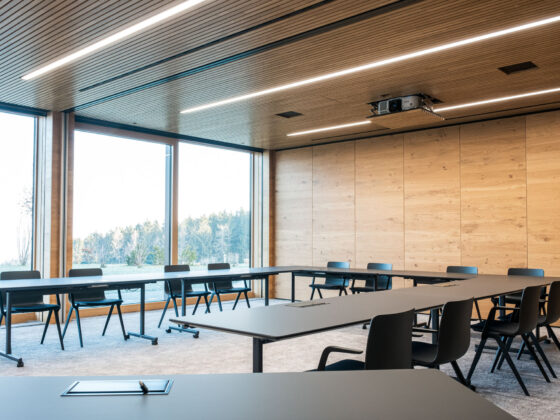 Moderner Konferenzraum mit Holzpaneelen und großen Fenstern.
