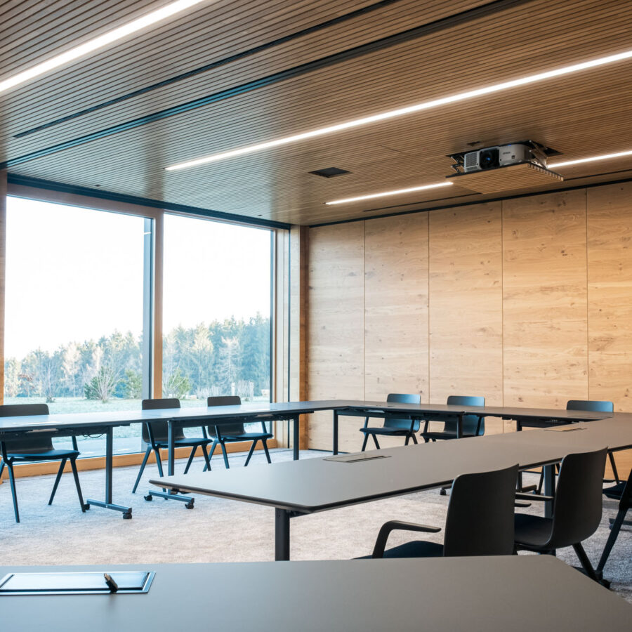 Moderner Konferenzraum mit Holzpaneelen und großen Fenstern.