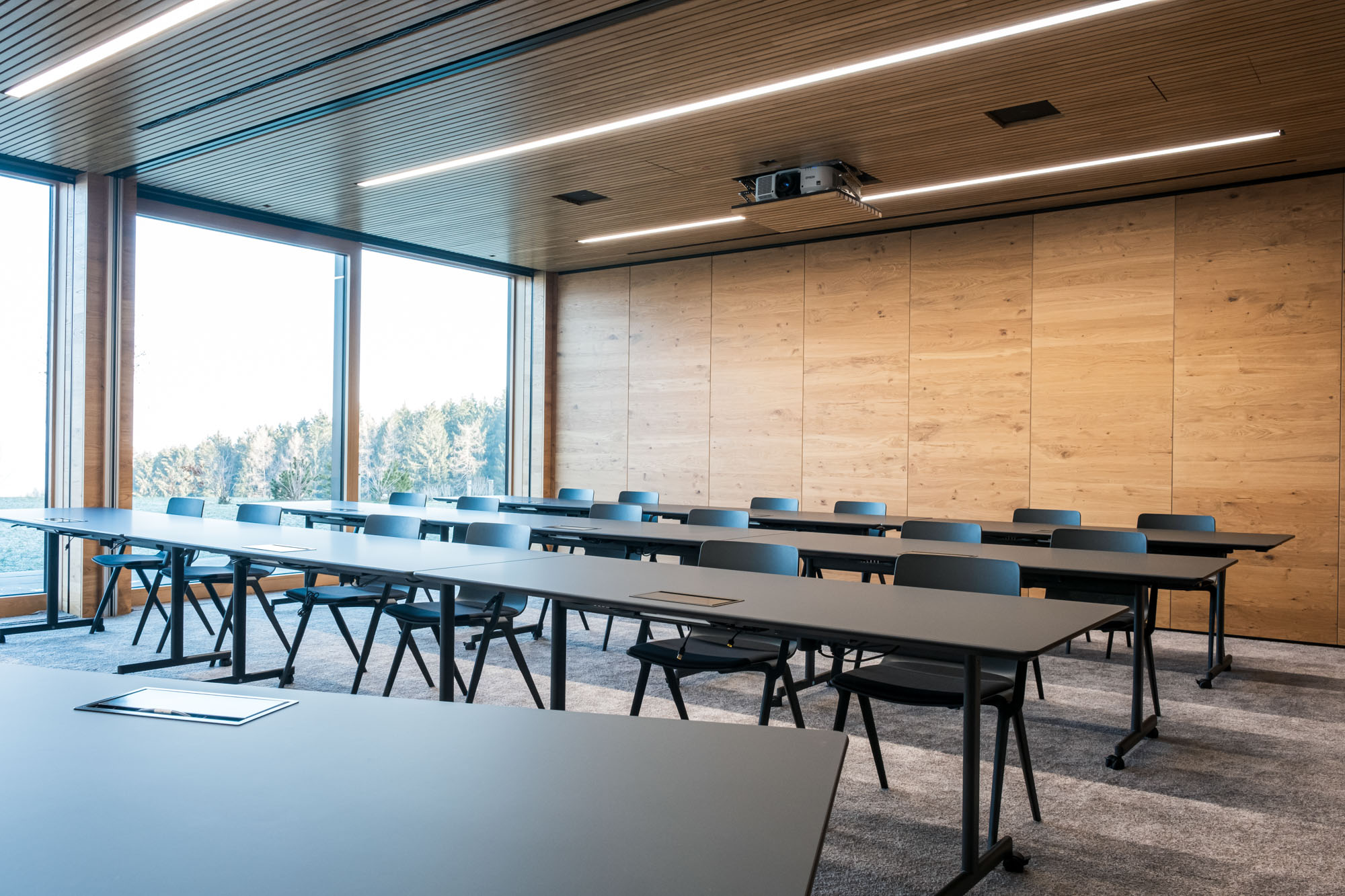 Moderne, leere Konferenzraum mit Holzdecke und großen Fenstern, ideal für Meetings.
