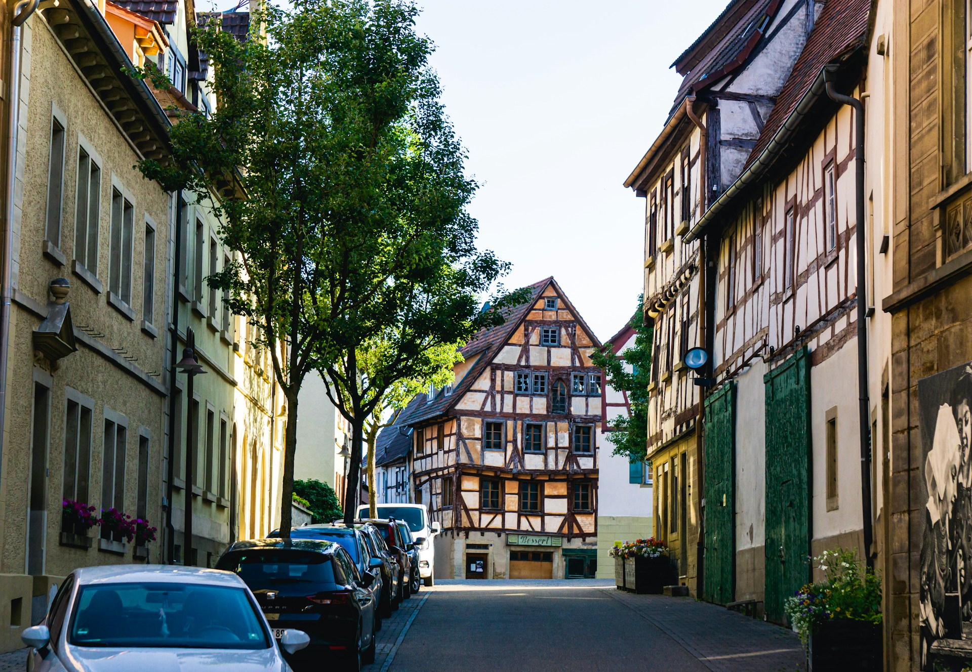 Historische Fachwerkhäuser an einer ruhigen, sonnigen Straßenszene in einer europäischen Altstadt.