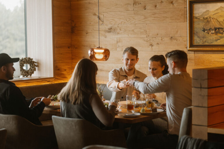 Menschen beim gemütlichen Essen in einem modernen Restaurant mit Holzdekor und warmem Licht.