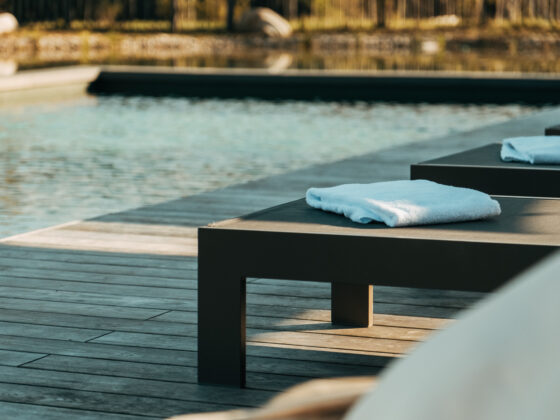 Liegen mit weißen Handtüchern am Pool im Sonnenuntergang.